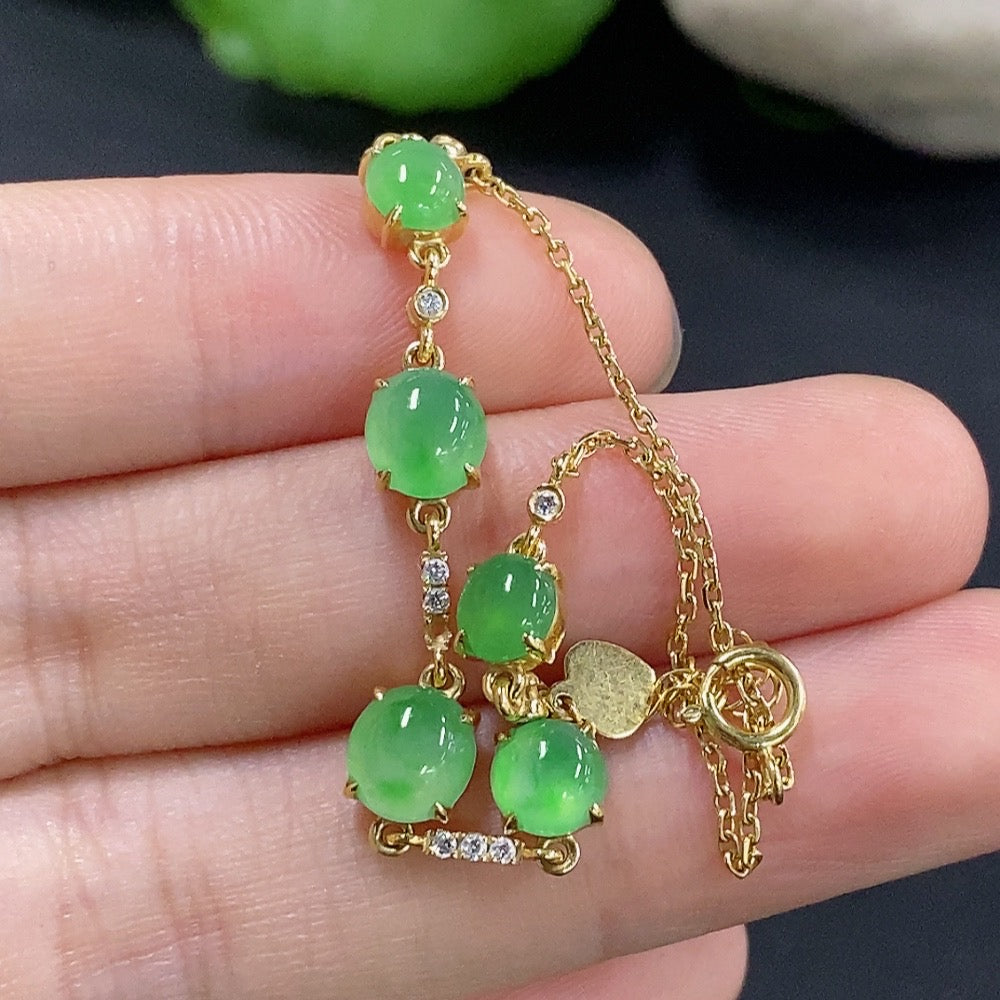 Jadeite cabochon bracelet with 18k gold and diamond accents, featuring smooth green jade stones and intricate gold detail.