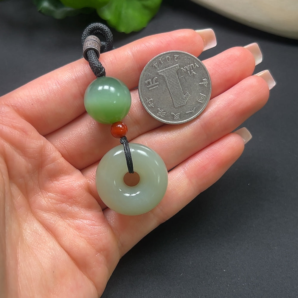 HKHQ Hetian Jade Peace Knot Pendant with Southern Red and Rope, showcasing the intricate jade design and vibrant red accents.