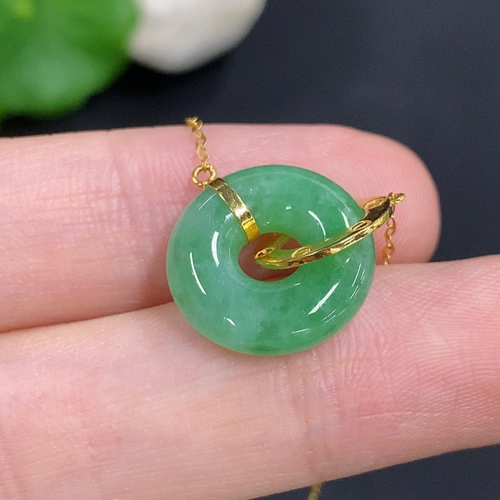 Jadeite donut pendant with 18k gold chain from HKHQ, showcasing a smooth green jade circular pendant on a delicate gold chain.