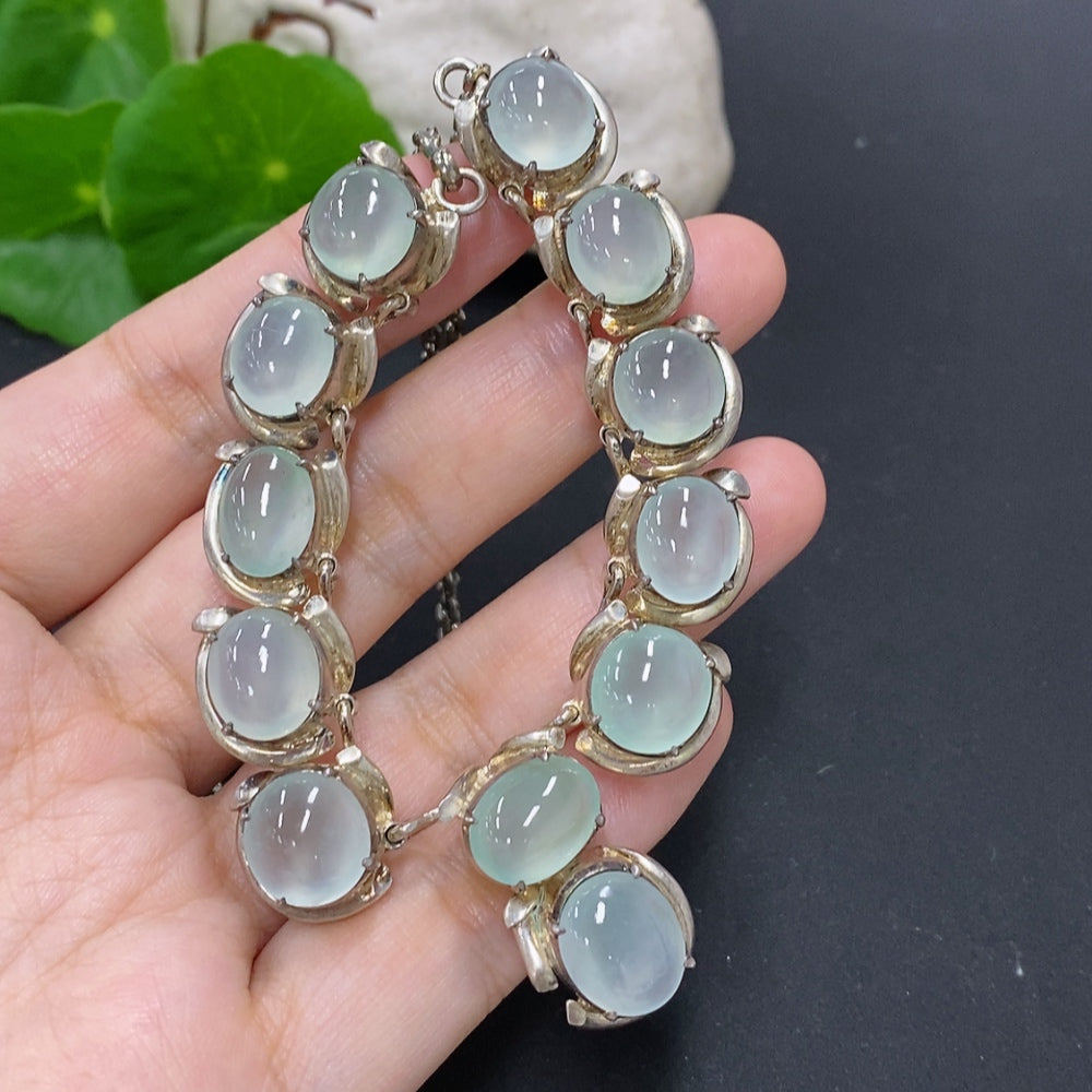 Jadeite cabochon gemstone in a non-gold setting, weighing approximately 61.2 grams, displayed on a neutral background.