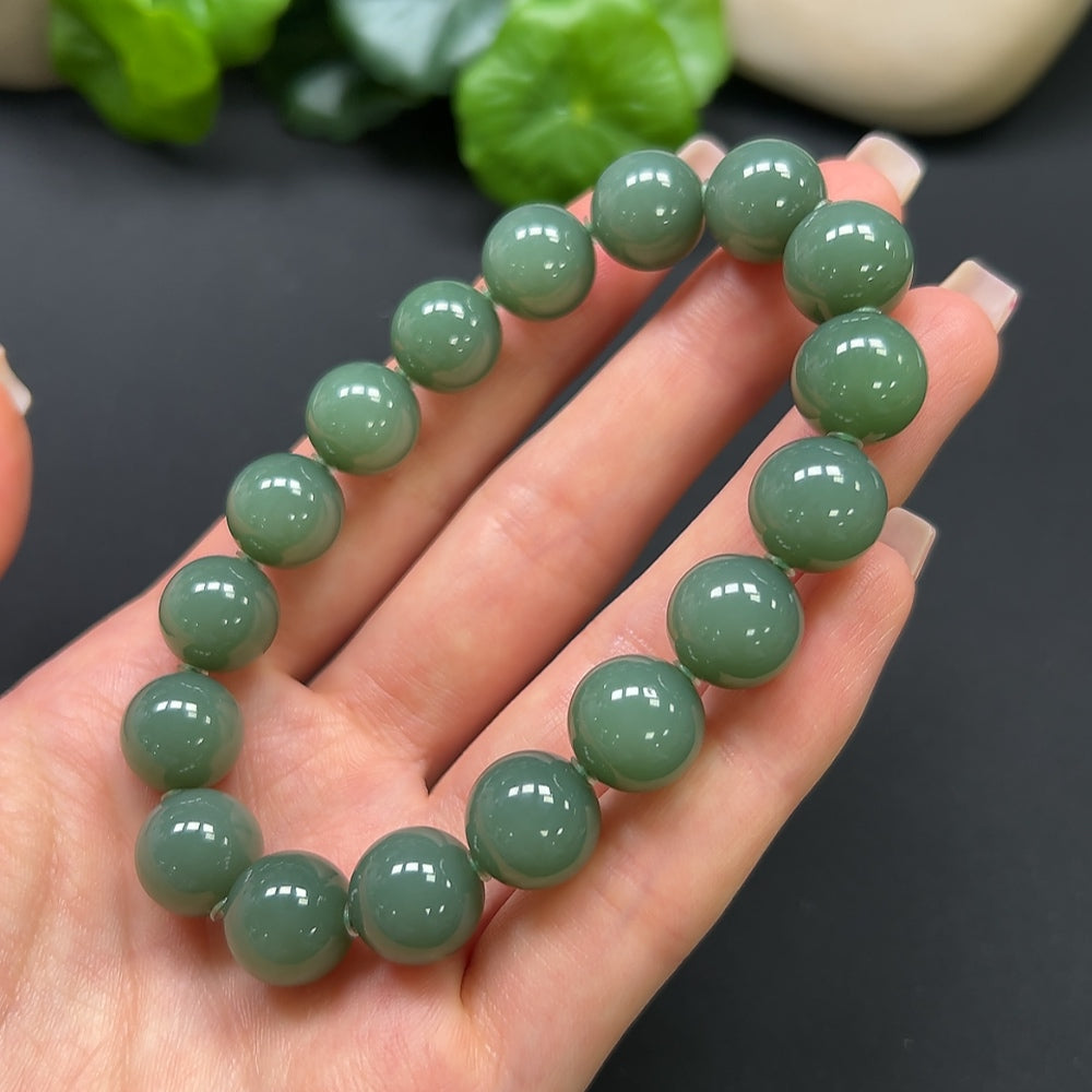 Hetian Jade bracelet by HKHQ featuring smooth, polished jade beads, weighing 45 grams, displayed in a close-up image.