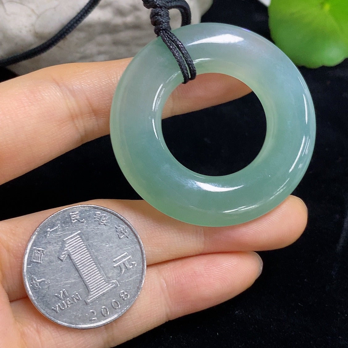 Jadeite Peace Ring Pendant featuring a polished jade jadeite stone with intricate design, hanging on a silver chain.