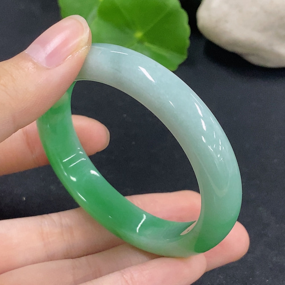 HKHQ Jadeite oval bangle in size 53.5, 38.88g, featuring smooth oval shape and vibrant green color, displayed on a plain background.