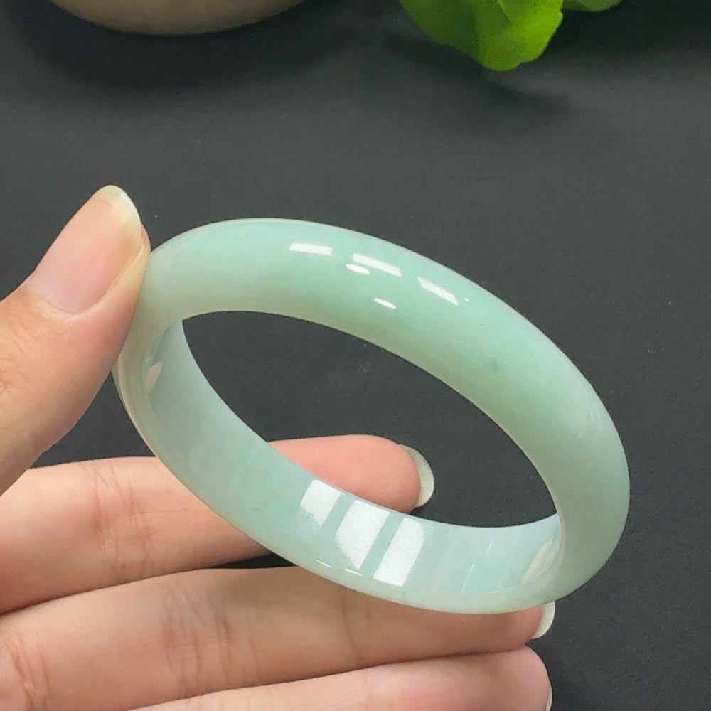 HKHQ jadeite round bangle, size 55.8, weighing approx. 45.69g, showcasing smooth, polished jade surface and elegant craftsmanship.