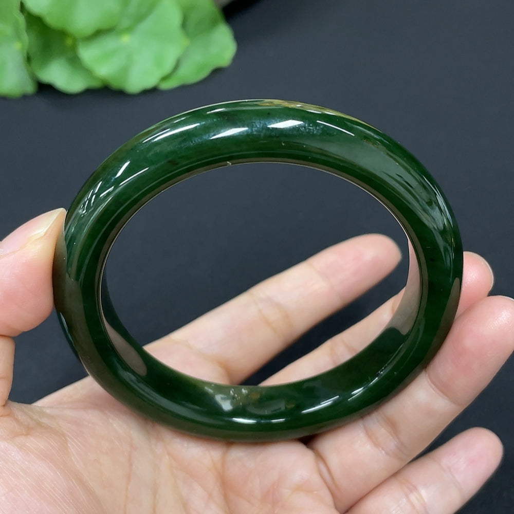 Green Hetian Jade round bangle bracelet from HKHQ, showcasing smooth, polished jade with a glossy finish.