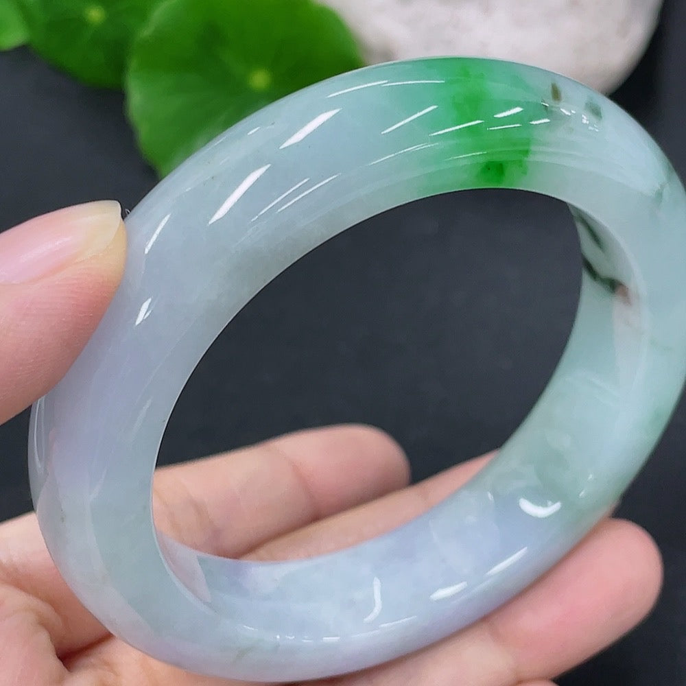 Close-up of a smooth jadeite round bangle bracelet by HKHQ, showcasing its polished jade surface and elegant circular shape.