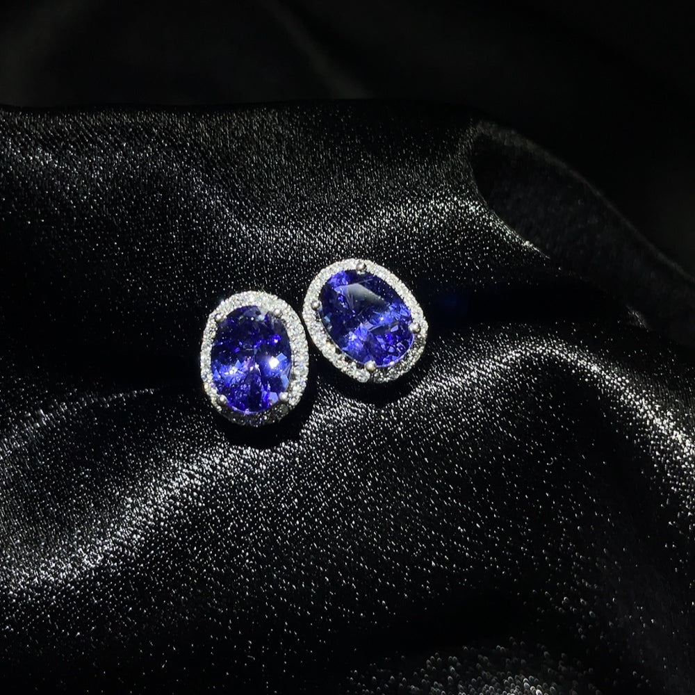 HKHQ 18K Tanzanite gemstone earrings, approximately 2.25g, featuring vibrant blue-purple tanzanite stones with gold settings.
