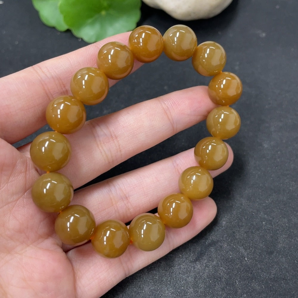 HKHQ Hetian Jade bracelet with 11.7mm beads, approx. 42g, showcasing smooth, polished jade stones on a delicate string.