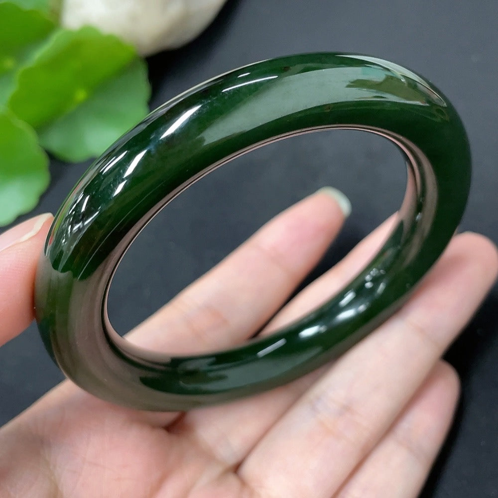 Green Hetian Jade round bangle with HKHQ branding, size 56.7, weighing approximately 58.8g, smooth and polished surface.