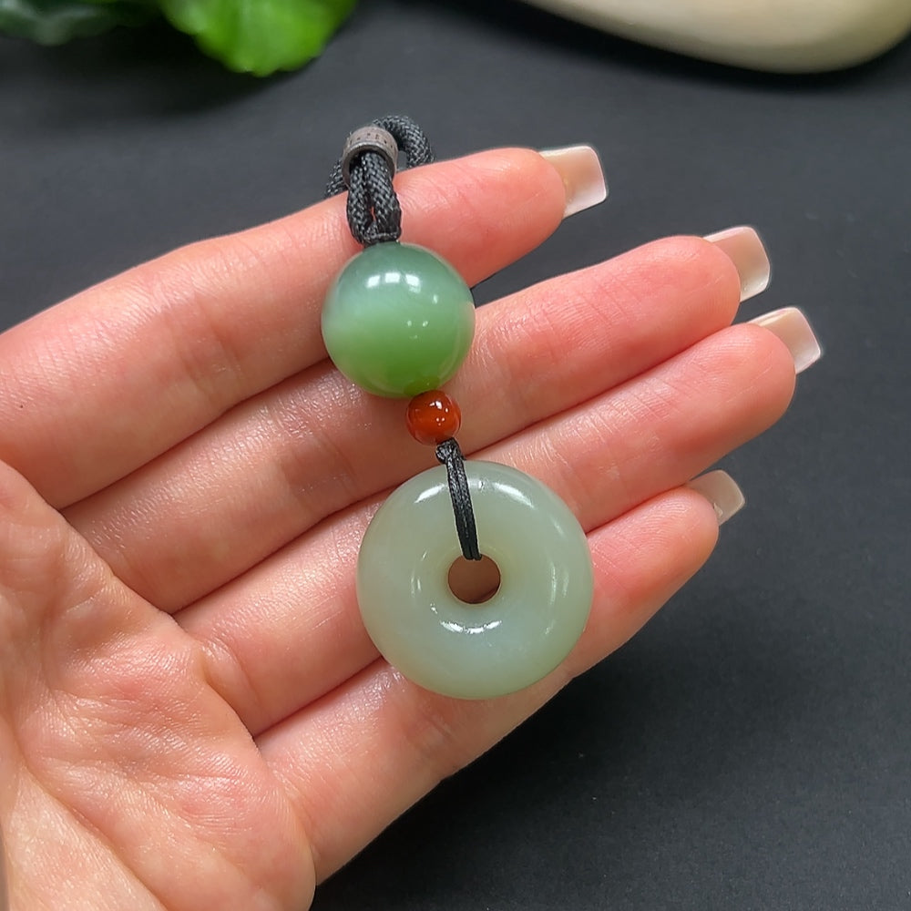 Hetian Jade Peace Knot Pendant with Southern Red, crafted by HKHQ, featuring a detailed jade design and included rope, weighs approx. 22.9g.