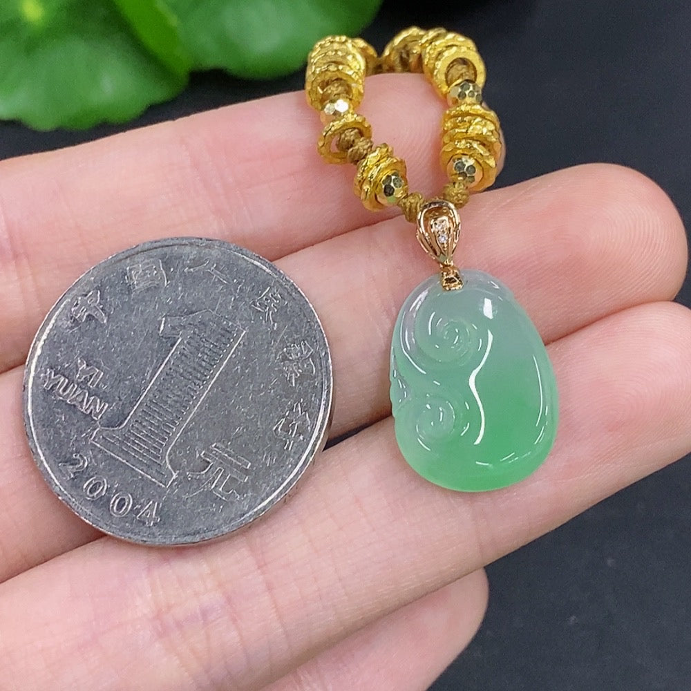 Jadeite Ruyi pendant with 18K gold accents and diamond details, hanging on a cord, showcasing intricate craftsmanship and vibrant green jade.