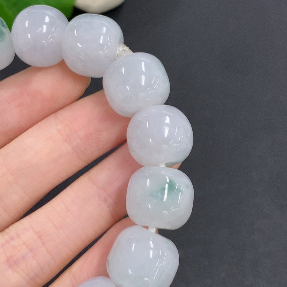 HKHQ jadeite bracelet weighing 83.3g, featuring smooth, polished green jadeite beads with a clasp, displayed on a neutral background.