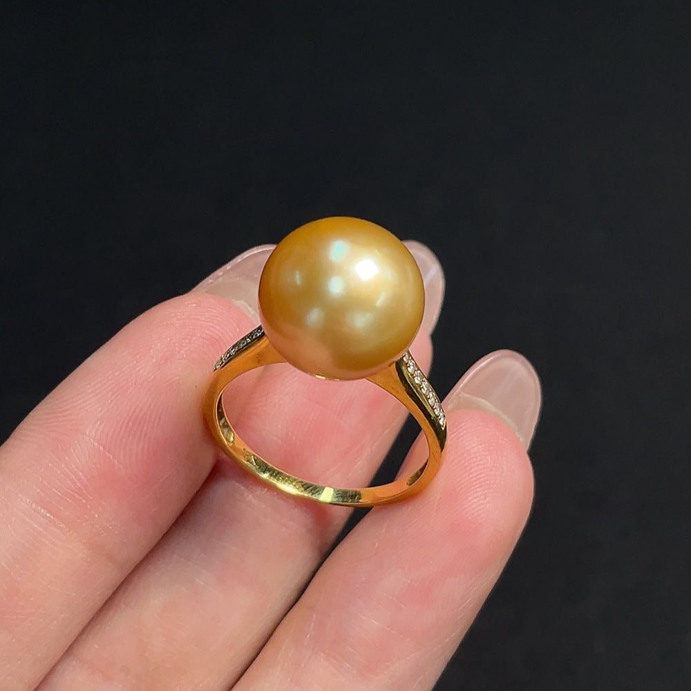 Seawater pearl ring with 18K gold band, diamond accents, size 17, featuring undetermined color origin and elegant design.