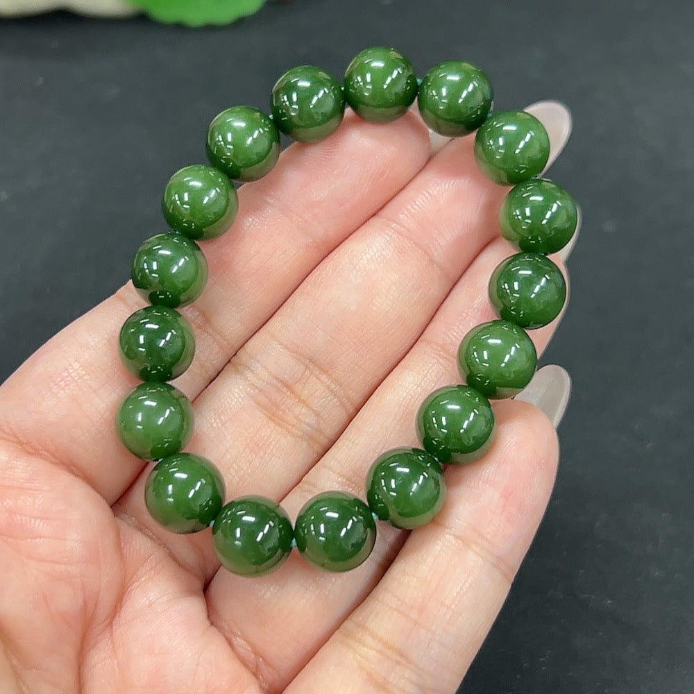 Hetian jade bracelet with 10mm beads from HKHQ, featuring a smooth, polished surface and weighing approximately 26.7 grams.