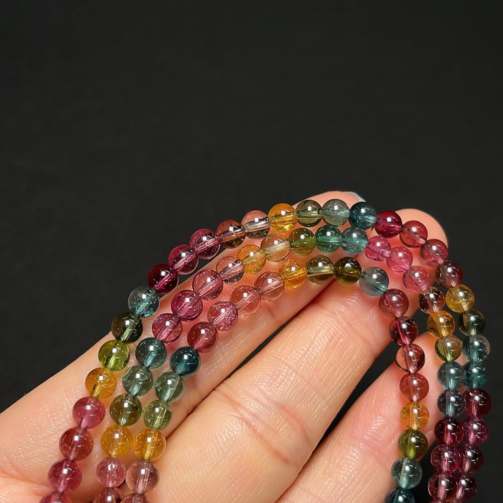 Tourmaline gemstone bead strand with visible organic matter, 4.3mm size, HKHQ brand, weighing approximately 18.99g.