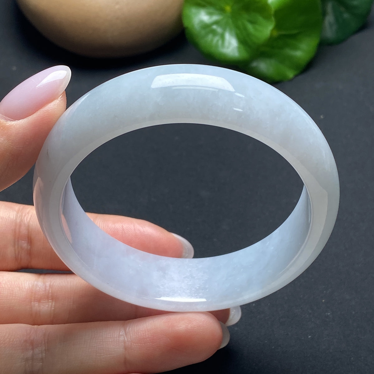 Elegant jadeite round bangle by HKHQ featuring smooth, polished jade with a glossy finish, showcasing traditional craftsmanship.
