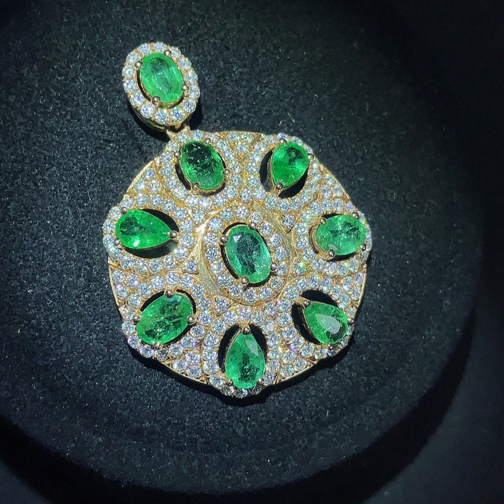 Emerald pendant with 18K gold setting, clarity enhanced, on a necklace chain, designed by HKHQ for elegant jewelry.