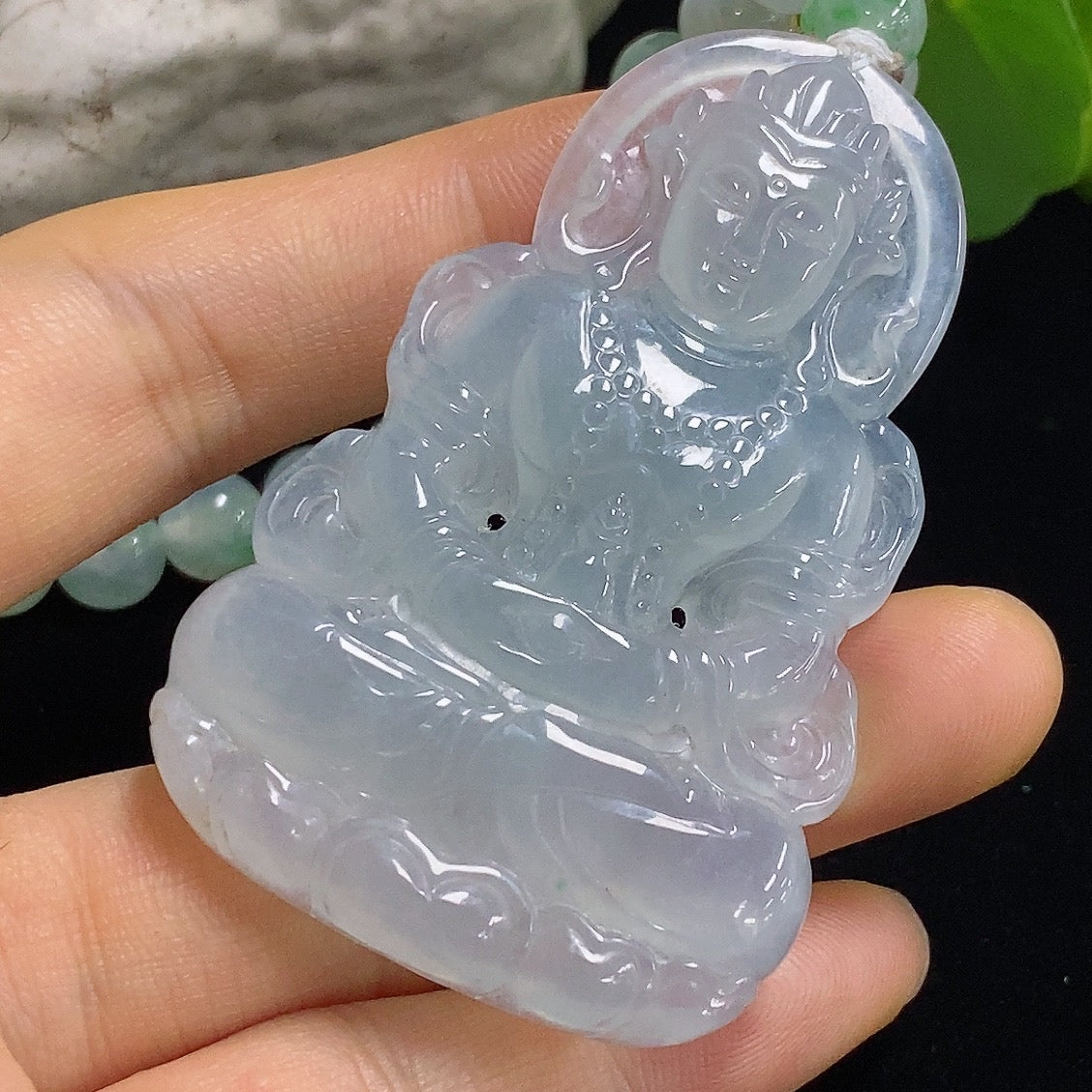 Jadeite Tara pendant from HKHQ featuring a smooth, polished green jade pendant with intricate carved details.