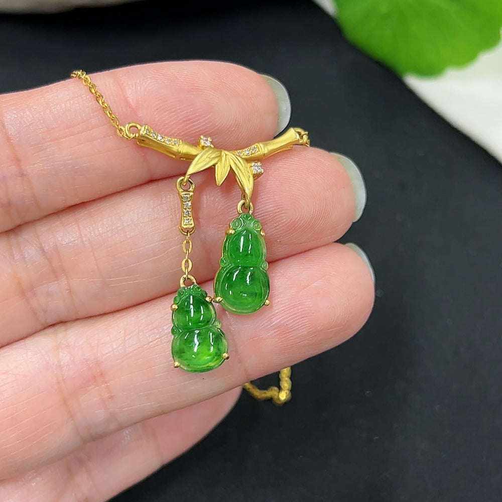 Jadeite inlaid gourd pendant with 18k gold and diamond accents, attached to a matching chain, displayed against a neutral background.