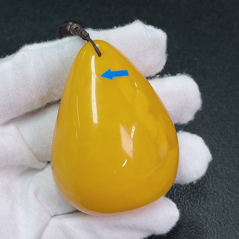 Amber and beeswax pendant with garnets, visible repairs, non-gold, gemstone set, weighs about 79g, by HKHQ.