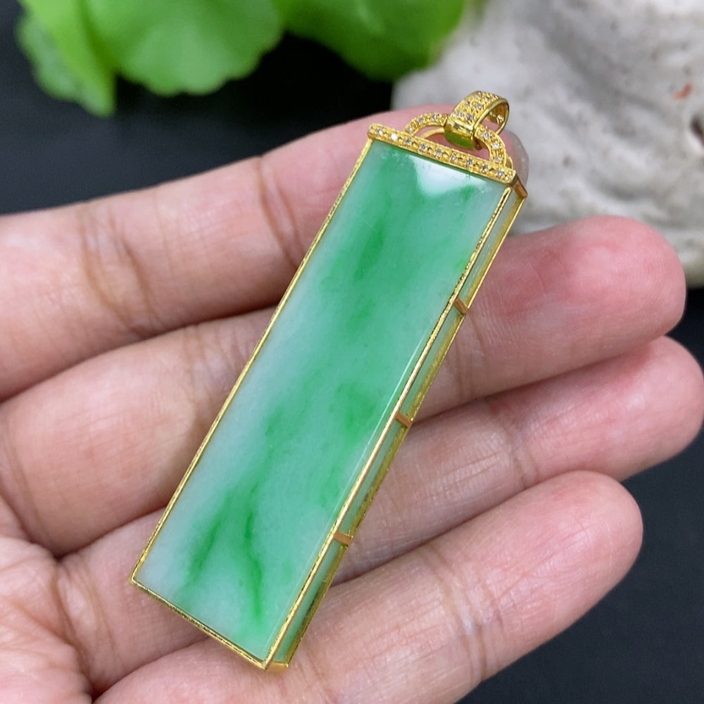Jadeite pendant necklace with 18K gold setting and diamond accents, shown on a chain with a polished finish.