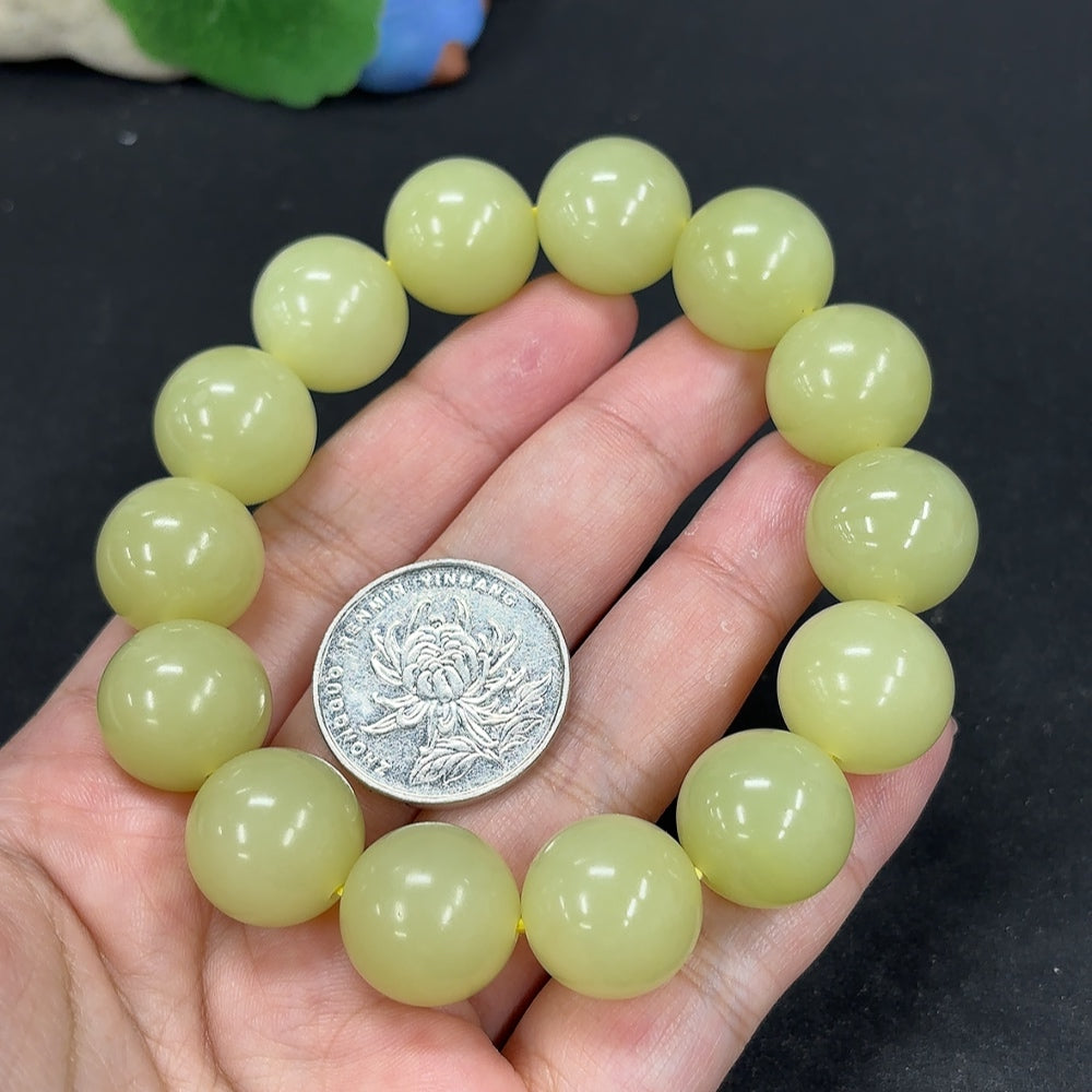 HKHQ Hetian Jade bracelet with 15.9mm beads and 91.4g weight, showcasing smooth, polished jade stones on a natural jewelry display.