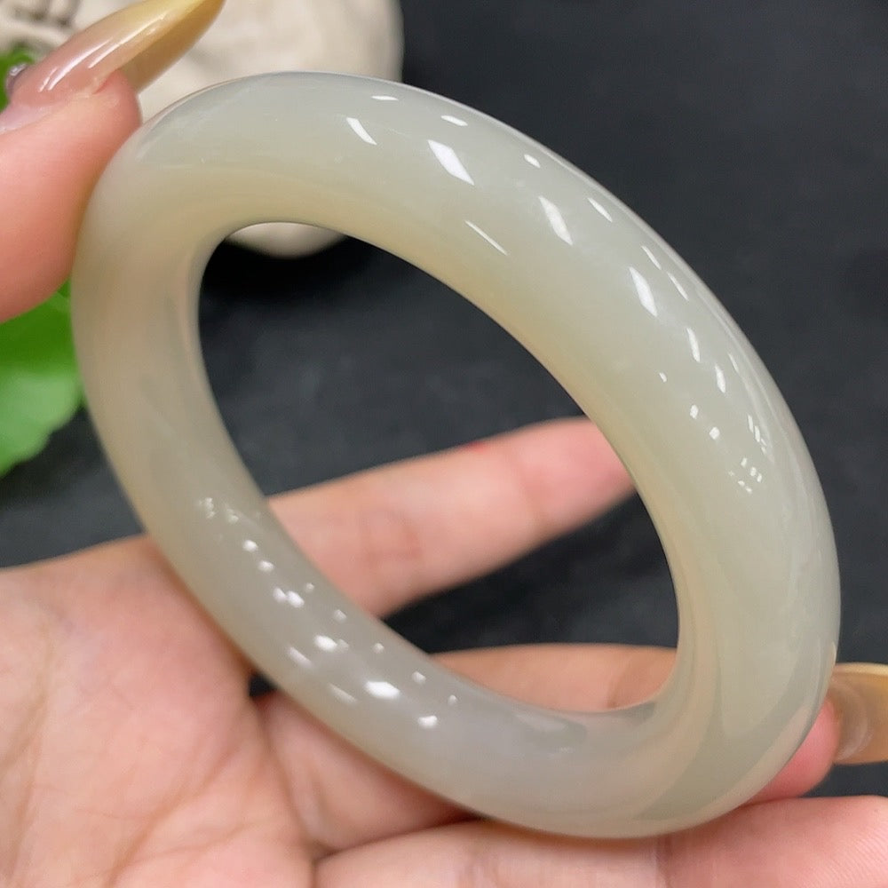 HKHQ Hetian Jade round bangle in size 54.7 with a smooth, polished surface and natural green hue, weighing 66.8g.