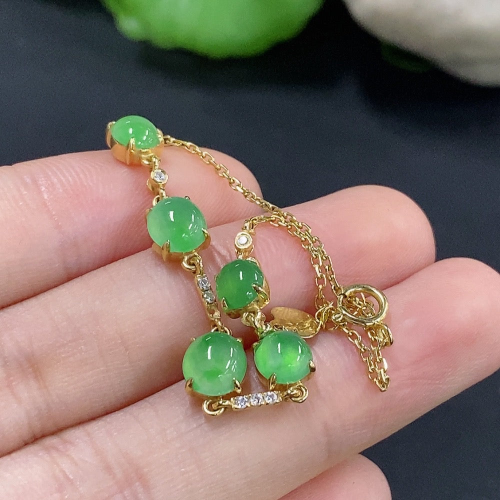 Jadeite cabochon bracelet with 18k gold and diamond accents, showcasing smooth green jade stones and elegant jewelry design.