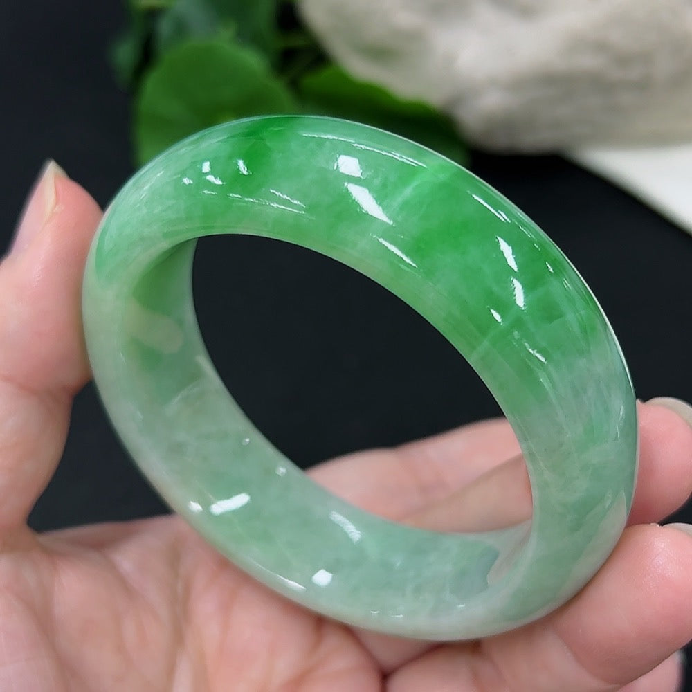 Jadeite round bangle with size 53.6 and weight 82.02g, showcasing smooth, polished jade surface in natural light.