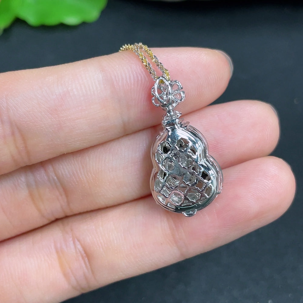 Jadeite gourd pendant with inlaid diamonds and 18k gold, displayed on a chain, showcasing intricate craftsmanship and vibrant green jade.