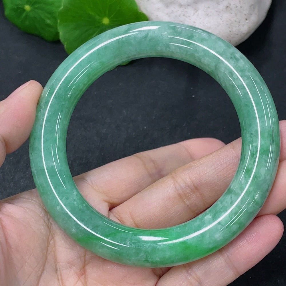 Jadeite round bangle with size 55.5mm, weighing approximately 76.95g, featuring smooth, polished jade surface and vibrant green color.